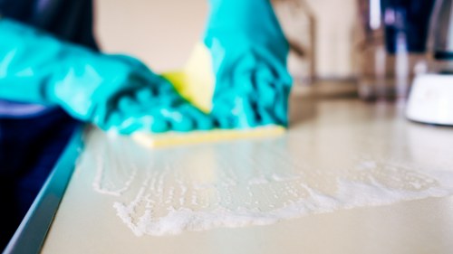 Local cleaner treating stains on a living room sofa in EC2